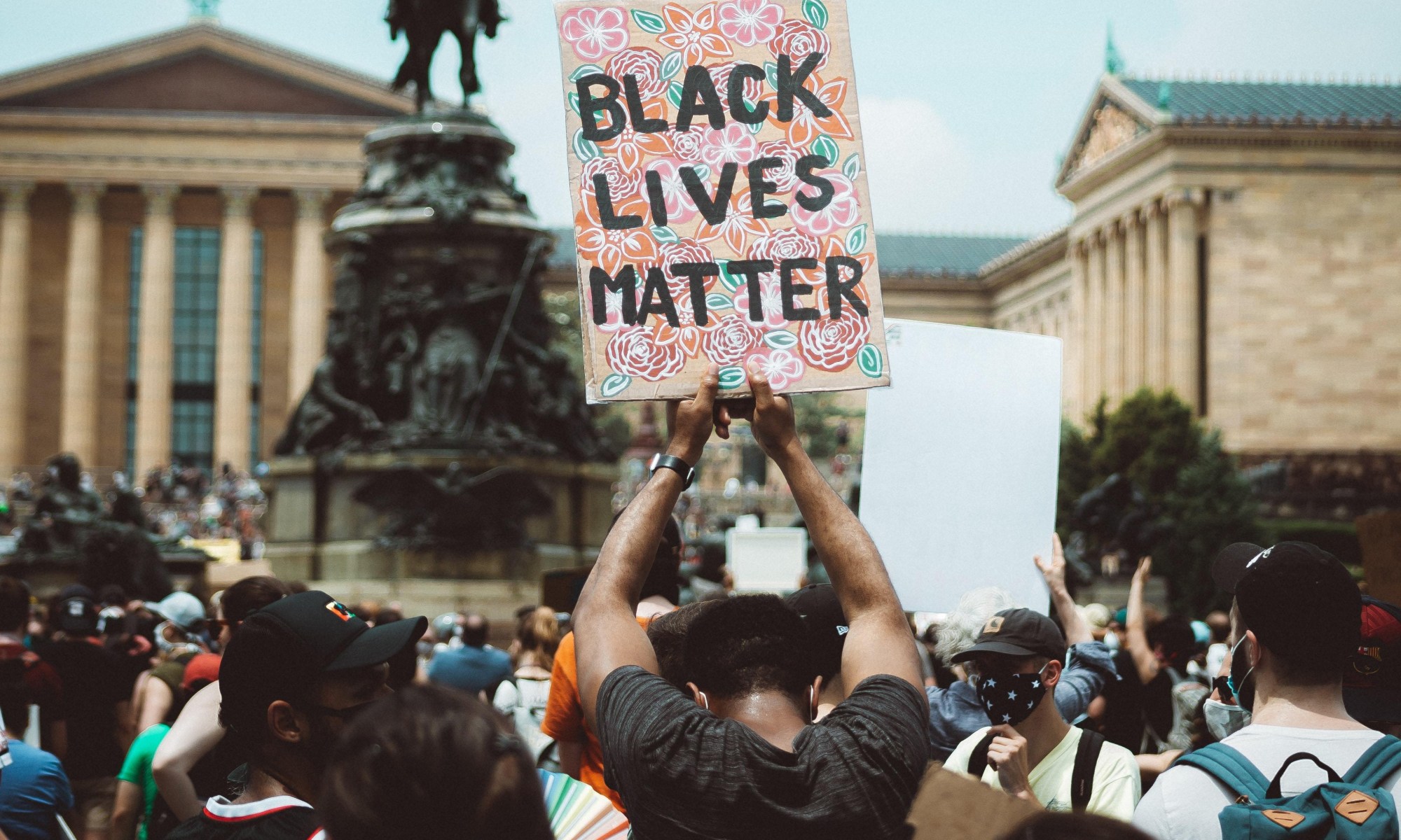 A person carrying a Black Lives Matter sign at a protest