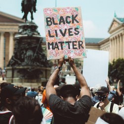 A person carrying a Black Lives Matter sign at a protest